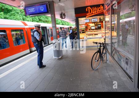 Hambourg, Allemagne. 07th juin 2022. Un agent de police fédéral regarde une bicyclette penchée contre des panneaux d'information sur une plate-forme. Un homme est décédé mardi après-midi à la gare de S-Bahn d'Ohlsdorf à Hambourg. Credit: Jonas Walzberg/dpa - ATTENTION: Personne(s) ont été pixelated pour des raisons juridiques/dpa/Alamy Live News Banque D'Images