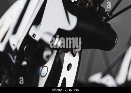 Gros plan du disque de frein de vélo avec système de freinage hydraulique sur autoroute Banque D'Images