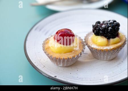 Deux petits gâteaux aux fruits italiens avec baies fraîches à bord Banque D'Images