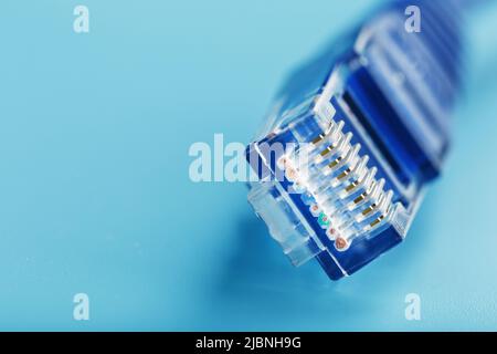 Bobine d'un câble réseau Internet pour la transmission de données sur fond bleu. Cordon de raccordement pour câble LAN. Banque D'Images