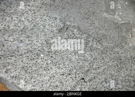 Béton fraîchement posé sur un chantier avec des marques laissées par la pluie de nuit Banque D'Images