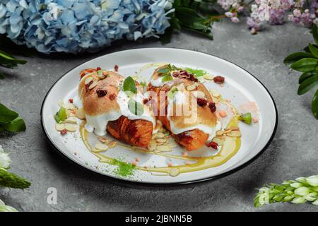 croissant à la crème douce et aux amandes sur une assiette. Petit déjeuner délicieux et sain Banque D'Images