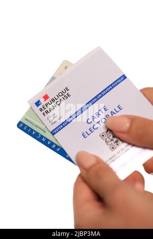 Paris, France - 26 mai 2022 : Une femme titulaire d'une carte d'identité nationale française et d'une carte électorale française sur fond blanc Banque D'Images