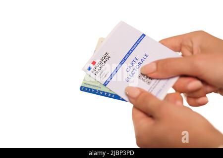 Paris, France - 26 mai 2022 : Une femme titulaire d'une carte d'identité nationale française et d'une carte électorale française sur fond blanc Banque D'Images