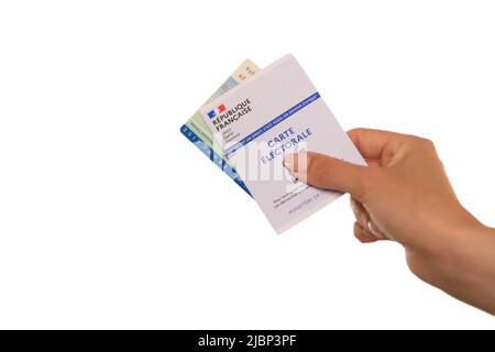 Paris, France - 26 mai 2022 : Une femme titulaire d'une carte d'identité nationale française et d'une carte électorale française sur fond blanc Banque D'Images