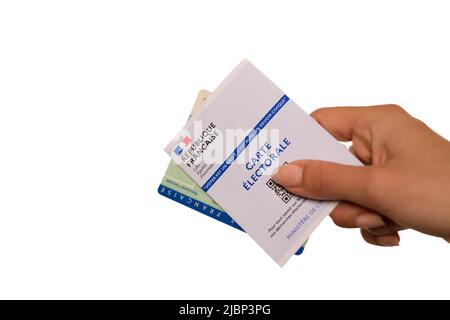 Paris, France - 26 mai 2022 : Une femme titulaire d'une carte d'identité nationale française et d'une carte électorale française sur fond blanc Banque D'Images