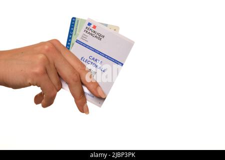 Paris, France - 26 mai 2022 : Une femme titulaire d'une carte d'identité nationale française et d'une carte électorale française sur fond blanc Banque D'Images