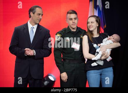 Houston Texas États-Unis, 27 mai 2022: Le directeur exécutif de l'Institut national d'action législative DE l'Association DES rifles JASON OUIMET félicite TYLER THOMAN, adjoint du shérif de Floride (centre), après avoir reçu un prix d'officier de l'application de la loi de l'année lors de la session générale de vendredi de la convention nationale de l'ARN. ©Bob Daemmrich Banque D'Images