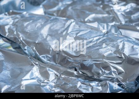 Feuille d'aluminium pour aliments crus emballée sur la plaque de cuisson en gros plan Banque D'Images