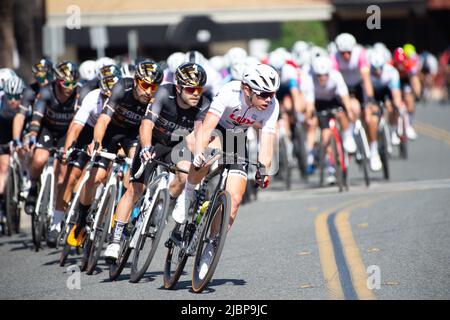 Les jeunes cyclistes amateurs dirigent l'étape critérium du Redlands Classic 2022 dans le centre-ville de Redlands, CA. Banque D'Images