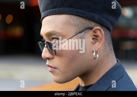 Portrait en gros plan de Latino gay masculin avec un chapeau de mode à maquillage Banque D'Images