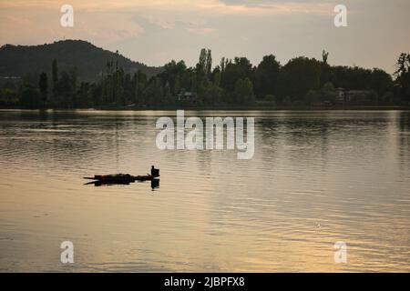 Srinagar, Inde. 24th mai 2022. Un boatman décale son bateau sur le lac Dal pendant le coucher du soleil. Crédit : SOPA Images Limited/Alamy Live News Banque D'Images