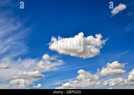 Des nuages blancs bouffis flottent sur un ciel bleu dans les régions rurales de l'Alberta au Canada Banque D'Images