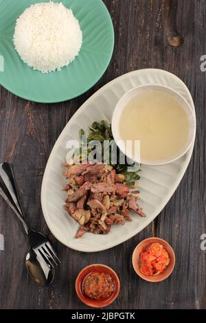 Bœuf Sai SAPI, bœuf traditionnel indonésien fumé, servi avec des feuilles de manioc bouillies et du luat de Sambal et du Matah de Sambal. Cuisine typique de Nusa Tengga Banque D'Images