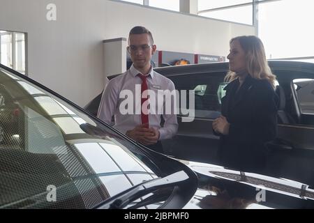 Kirov, Russie - 12 avril 2022: Directeur vendeur et acheteur dans la salle d'exposition avec des voitures de la concession Nissan dans la ville de Kirov Banque D'Images