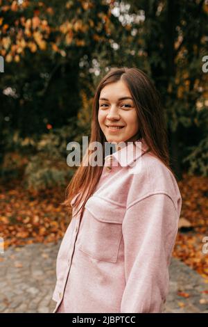 Portrait d'automne d'une jeune femme attrayante qui sourit joyeusement lors d'une marche à pied le jour d'automne chaud dans le parc volant. Été indien. Week-end. Entrée Banque D'Images