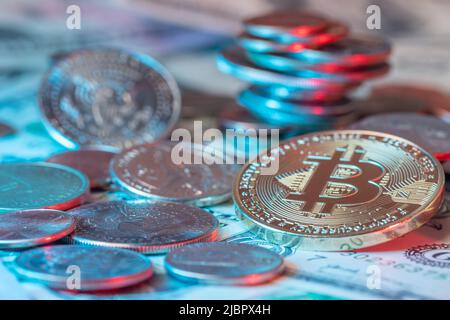 Bitcoin d'or à côté des pièces de monnaie et des billets de banque en dollars. Le dollar AMÉRICAIN a accumulé des pièces de monnaie et de l'argent du papier en arrière-plan. Crypto-monnaie et technologie blockchain Banque D'Images