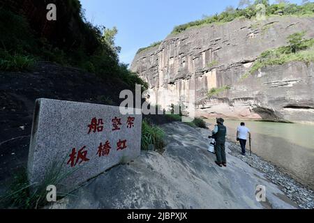 (220608) -- WUYISHAN, 8 juin 2022 (Xinhua) -- les touristes visitent l'ancienne relique des abris de roche avec des cercueils de bateau en bois du mont Wuyi dans la province du Fujian, au sud-est de la Chine, au 6 juin 2022. Le mont Wuyi, situé dans la province de Fujian, au sud-est de la Chine, est un paysage d'une grande beauté, dans lequel les pics et les rochers de formes grotesques sont girdés par des ruisseaux clairs et embrayés par des arbres verts et des plantes de bambou. En tant qu'habitat pour un grand nombre d'espèces sauvages, il est d'une importance énorme pour la conservation de la biodiversité. Il y a une série de sites archéologiques exceptionnels au mont Wuyi, y compris Banque D'Images