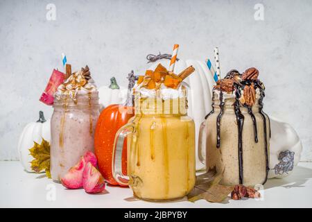 Boissons fouettées aux pommes, à la citrouille et à la tarte aux noix de pécan.Ensemble traditionnel de cocktails aux saveurs de gâteaux d'automne, sur fond blanc Banque D'Images