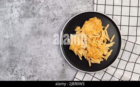 Mac et fromage, pâtes de style américain avec sauce cheesy et garniture croquante sur une assiette ronde sur fond gris foncé. Vue de dessus, plan d'appartement Banque D'Images