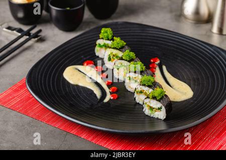 Ensemble de sushi de divers produits sur une assiette en pierre noire Banque D'Images