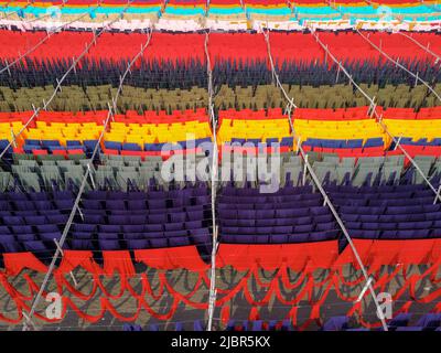 8 juin 2022, Narayanganj, Dhaka, Bangladesh : les travailleurs pendent des milliers de mètres de tissus de différentes couleurs pour les sécher afin de pouvoir les transformer en tee-shirts et gilets. Des fils de fer sont utilisés entre les cadres de bambou pour créer des lignes de lavage géantes pour la dernière partie du processus de mort, car les tissus sont séchés au soleil à Narayanganj, au Bangladesh. Fils lumineux de bleu, rose, orange, rouge, violet, des chiffons teints jaune, magenta et vert sont suspendus au-dessus du champ herbacé dans un réseau éblouissant de couleurs entrelacés. Après cinq à six heures au soleil, le tissu est utilisé pour faire des robes.c'est la finale Banque D'Images