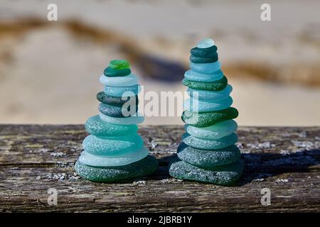 Équilibre des pierres. Pierres de verre sur une table en bois contre la mer. Deux pyramides Banque D'Images