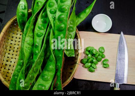 parkia speciosa frais avec couteau à graines et à poulet sur panneau de cuttig Banque D'Images