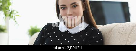 Brunette jolie femme lisant sur une histoire de fiction de canapé Banque D'Images