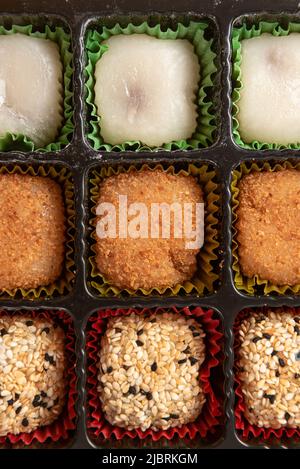 Bonbons japonais Mochi dans l'emballage d'usine sur fond jaune. Banque D'Images