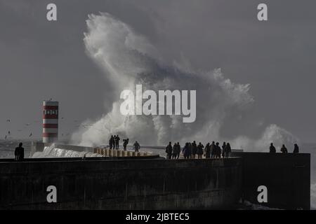 Porto, Portugal - 02 janvier 2016: Les gens qui regardent la tempête dans le fleuve Douro bouche nouveau quai et balise. Banque D'Images