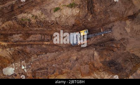 Vue aérienne d'une pelle hydraulique creusant la route sur un chantier de construction - espace de copie. Photo de haute qualité Banque D'Images