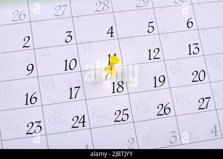 Punaise jaune sur le 18th jour d'un calendrier. Événement ou congé marqué. Banque D'Images