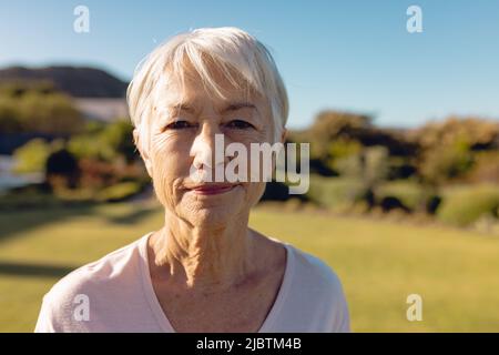 Portrait rapproché d'une femme asiatique âgée avec des cheveux courts contre le ciel bleu clair dans la cour le jour ensoleillé Banque D'Images