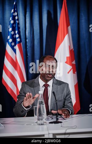 Homme politique afro-américain en costume assis à la table et parlant de la situation politique dans les pays pendant la conférence Banque D'Images