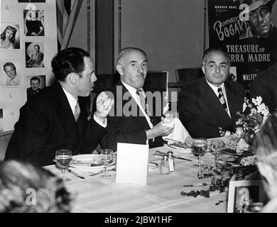 Visite à Warner Bros. Producteur exécutif JACK L. WARNER (au centre) et vice-président exécutif et trésorier SAMUEL SCHNEIDER à la British Exhibition's Convention / réception à Londres en 1948 publicité pour Warner Bros. Banque D'Images