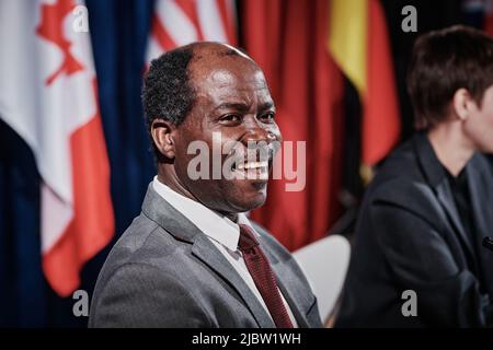 Un homme politique afro-américain en costume riant lors d'une rencontre internationale avec ses collègues Banque D'Images