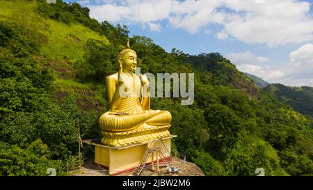 Une statue du Bouddha d'or dans un temple bouddhiste de montagne. Temple du Rocher d'Aluvihara, Matale, province centrale, Sri Lanka Banque D'Images