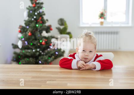 Enfant fille vêtue d'une robe de noël avec implants cochléaires s'amusant à la maison - diversité et aide auditive et technologies innovantes pour le traitement Banque D'Images