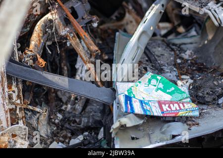 La voiture a complètement brûlé. Une carte papier de la ville de Kiev à l'intérieur d'une voiture détruite. Zone sinistrée. Voiture abandonnée sur la route. Ukraine, Banque D'Images