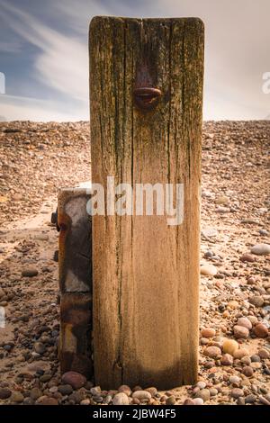 Un portrait d'été image HDR d'un poste de tête de gondole brise-lames en bois avec un boulon à œil sur Findhorn Beach, Moray, Écosse. 30 mai 2022 Banque D'Images