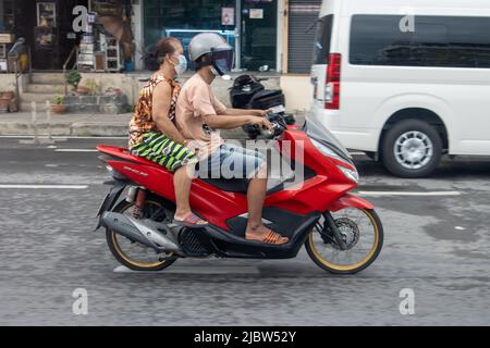 SAMUT PRAKAN, THAÏLANDE, MAI 08 2022, Un couple fait une promenade en moto dans une rue de la ville Banque D'Images