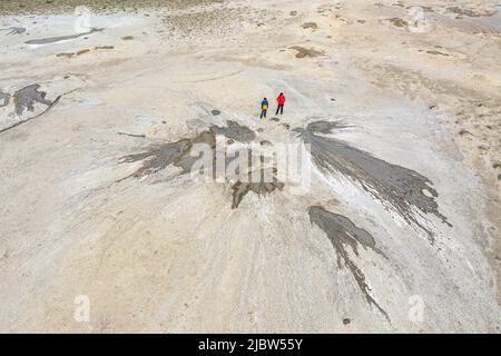 Vue aérienne de la mère et du fils se tenant sur les cratères des volcans de boue à Takkhti-Tepha dans la réserve naturelle de Chachuna, Géorgie Banque D'Images