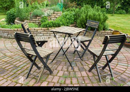 spirale d'herbes dans le jardin et table avec chaises Banque D'Images