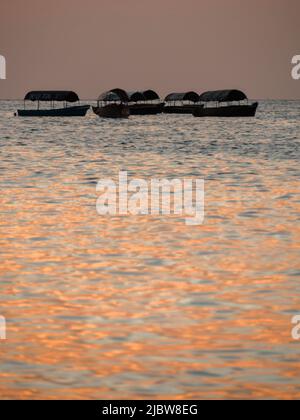 Coucher de soleil sur l'océan Indien vu de la promenade du port à Stone Town, Zanzibar, Tanzanie, Afrique Banque D'Images