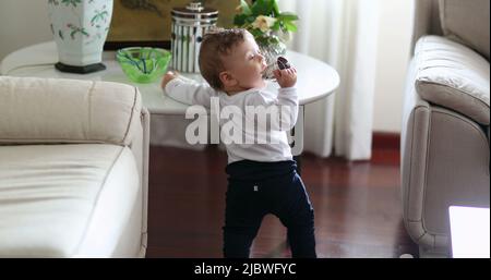 Bébé garçon debout à la maison s'appuyant sur la tablette de meubles de maison Banque D'Images