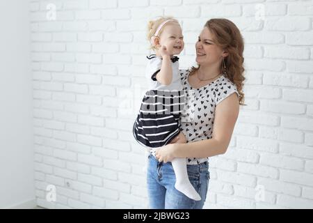 Bébé avec implant cochléaire aide auditive s'amuser avec sa mère - surdité et concept de diversité. Copier l'espace et l'emplacement pour la publicité Banque D'Images