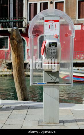 Venise, VE, Italie - 18 mai 2020: Ancienne boîte de téléphone italienne et le canal navigable en arrière-plan Banque D'Images