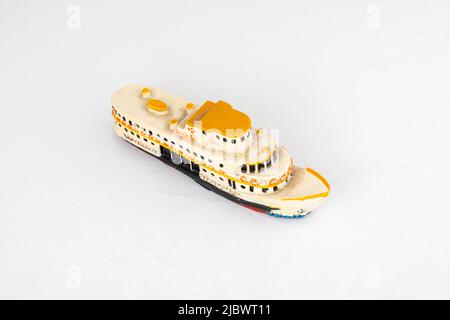 Vue rognée d'une photo de jouet en forme de petit bateau avec mise au point sélective à partir de l'angle supérieur sur fond blanc. Banque D'Images