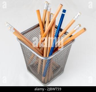 Un crayon bleu parmi les crayons du porte-crayons. Banque D'Images